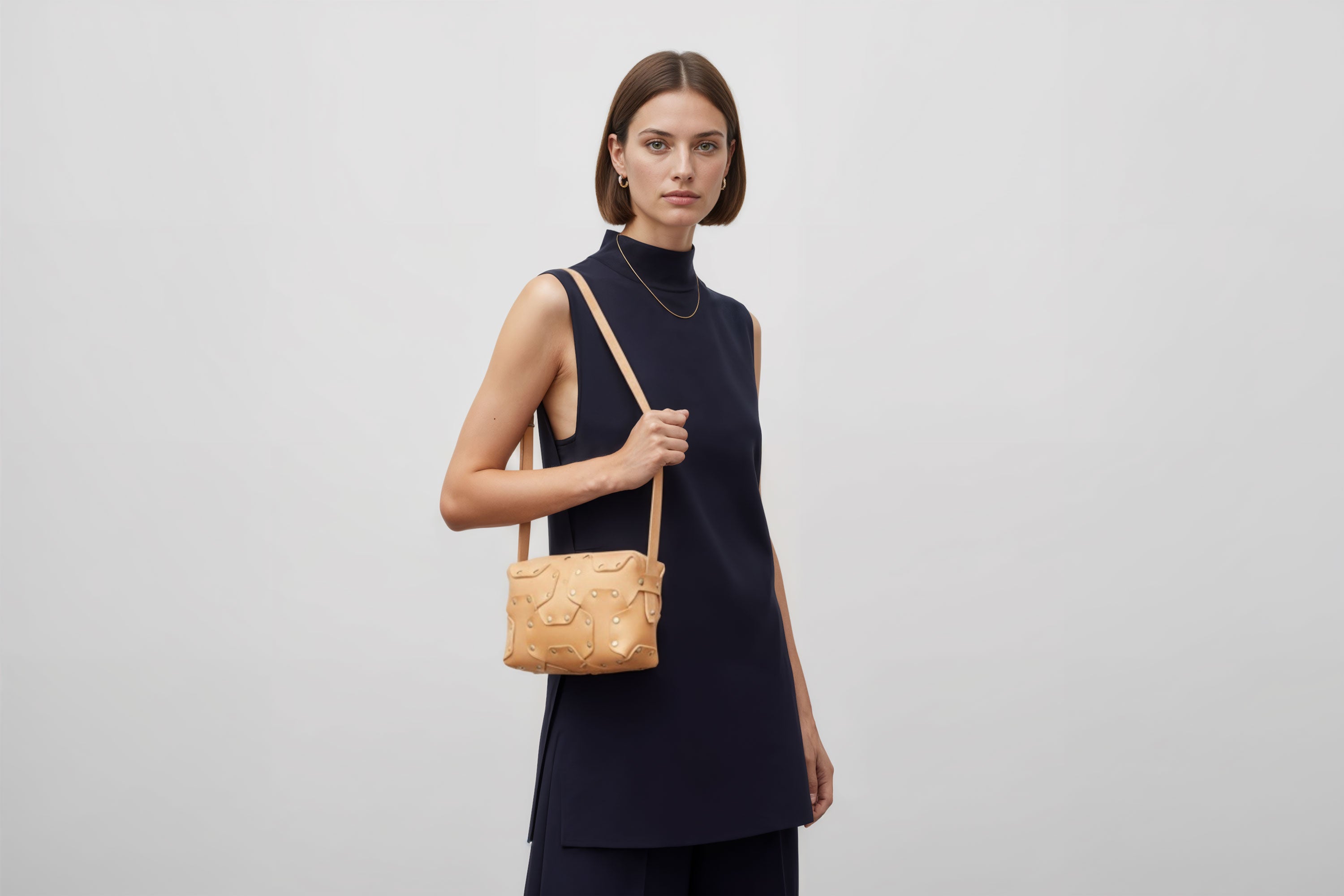 Double Rivet Bag Natural Color On A Woman Model Leather Full Grain Vegetable Tanned Leather Modern Minimalist Design Premium Quality Full Brass Clutch Crossbody Shoulder Bag Atelier Madre Manuel Dreesmann Barcelona Spain