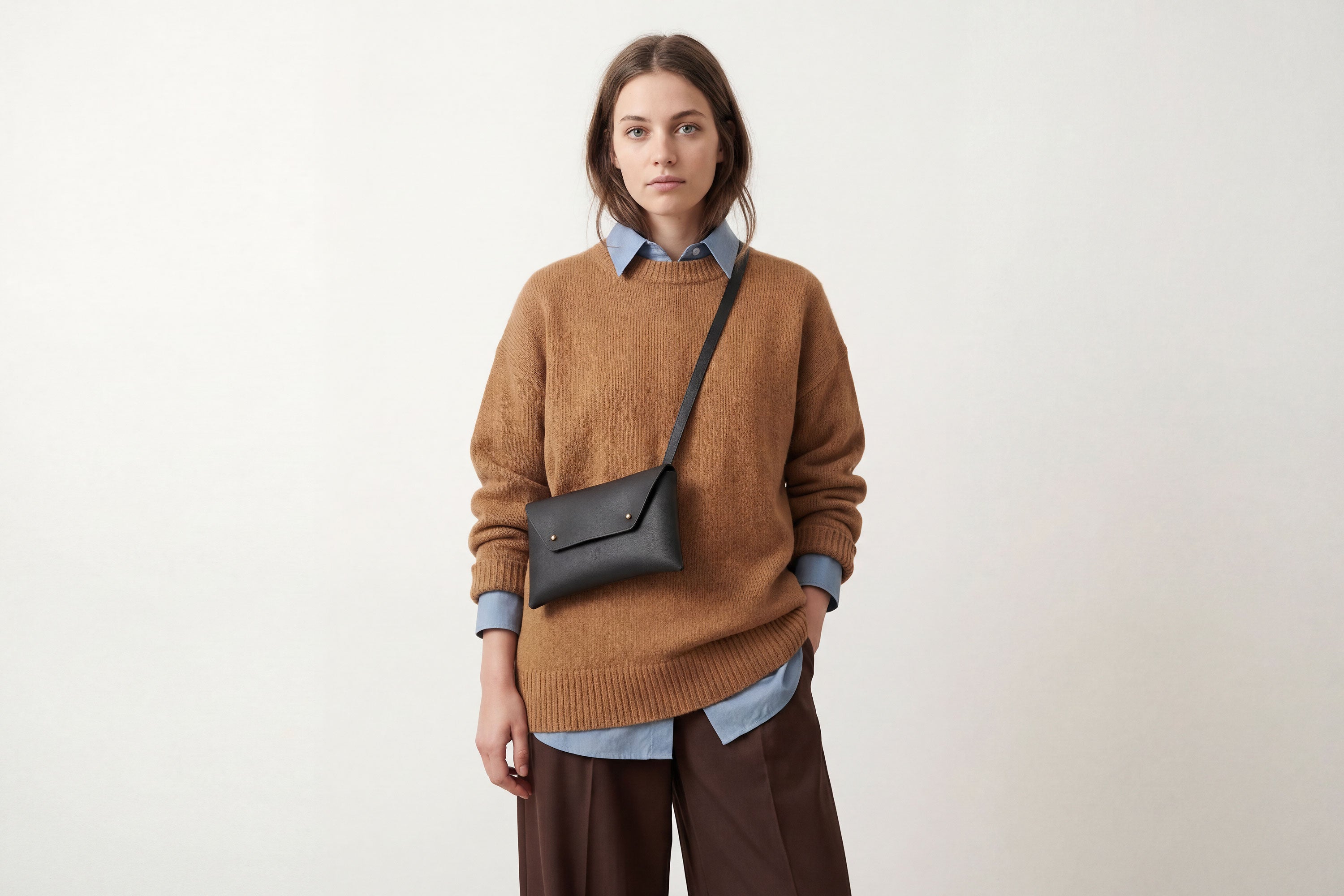 Envelope Bag With a Strap In Black Color On A Woman Model Vegetable Tanned Leather Minimalistic Design Atelier Madre Manuel Dreesmann Barcelona Spain