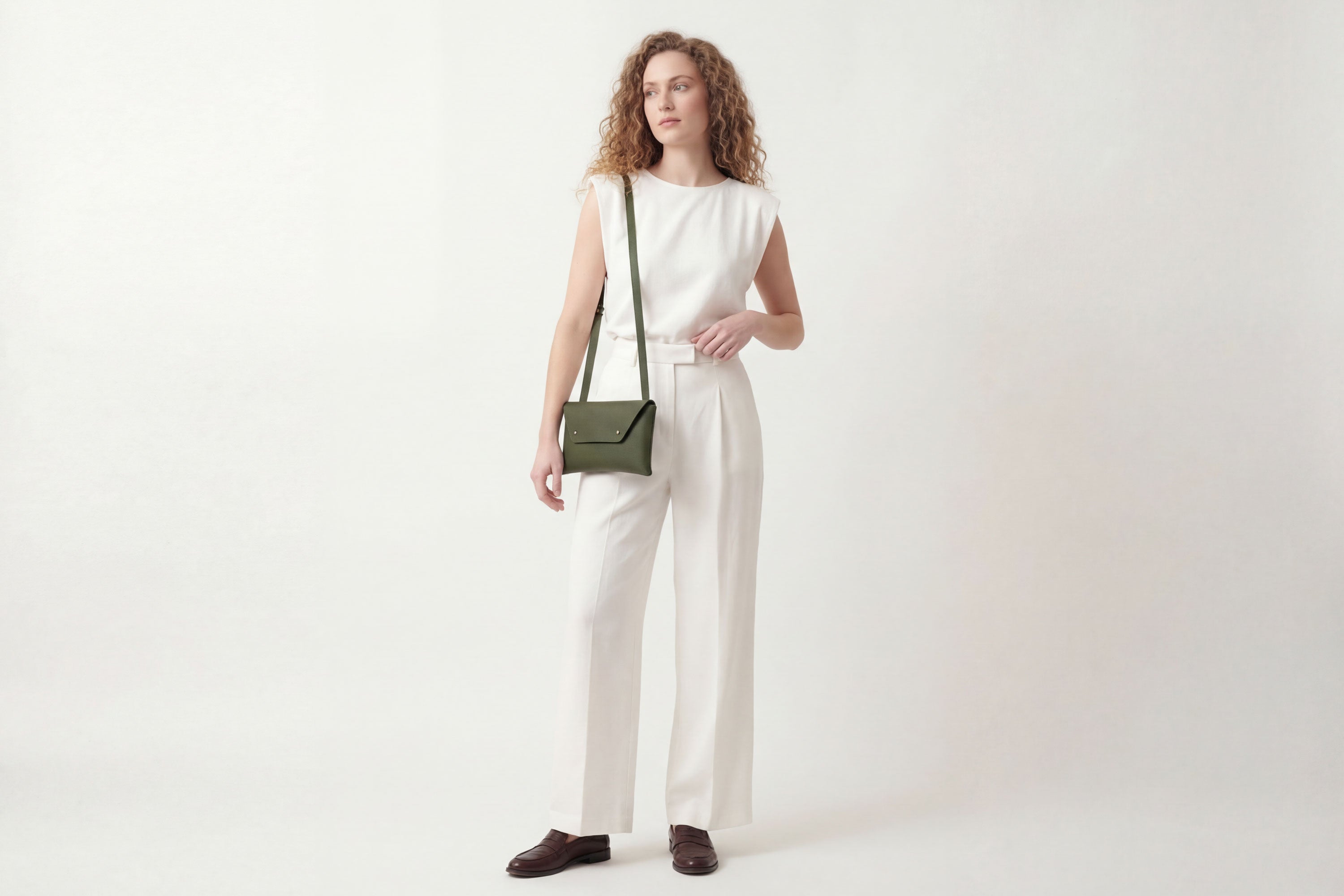 Envelope Bag With a Strap In Olive Green Color On A Woman Model Vegetable Tanned Leather Minimalistic Design Atelier Madre Manuel Dreesmann Barcelona Spain
