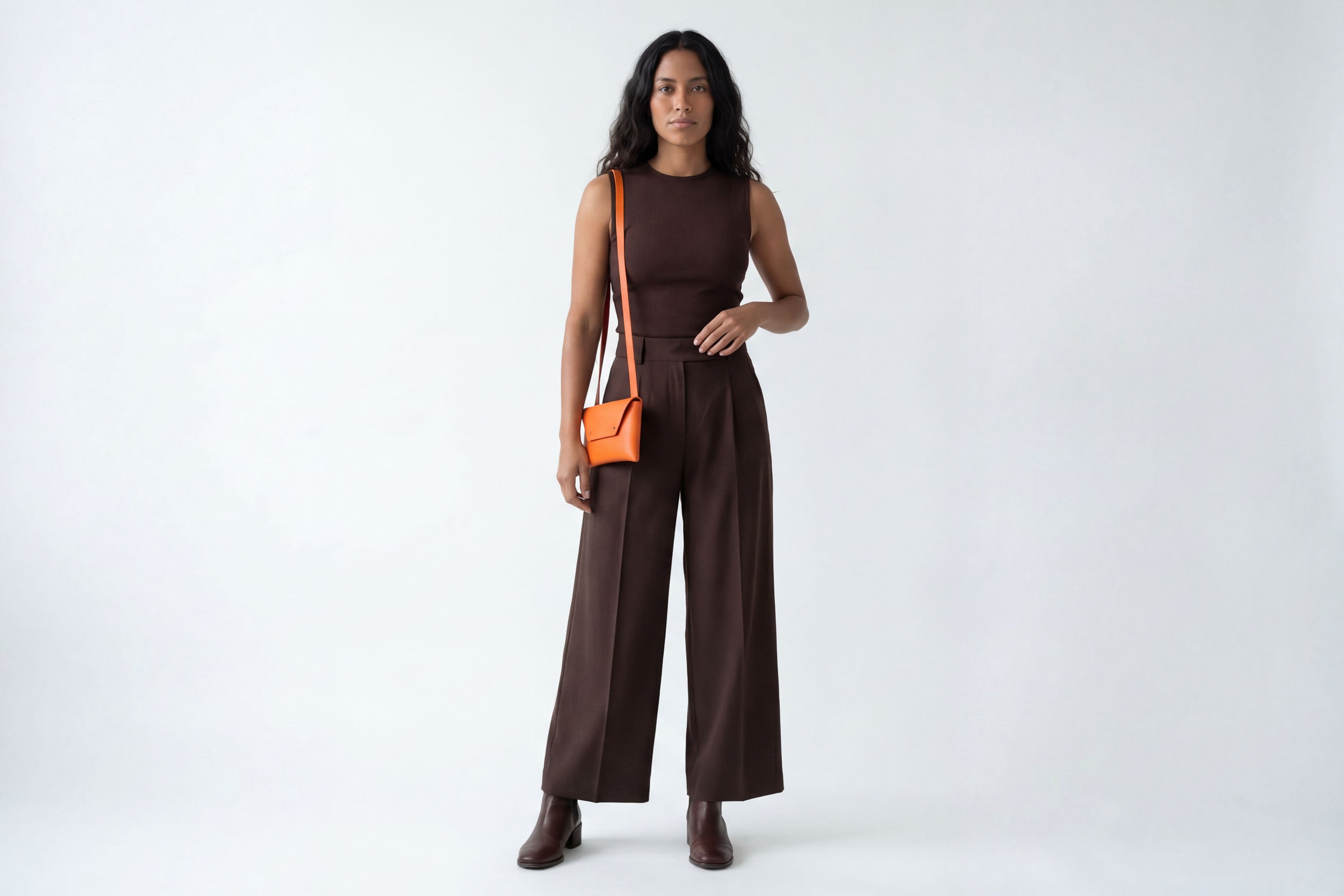 Envelope Bag With a Strap In Orange Color On A Woman Model Vegetable Tanned Leather Minimalistic Design Atelier Madre Manuel Dreesmann Barcelona Spain