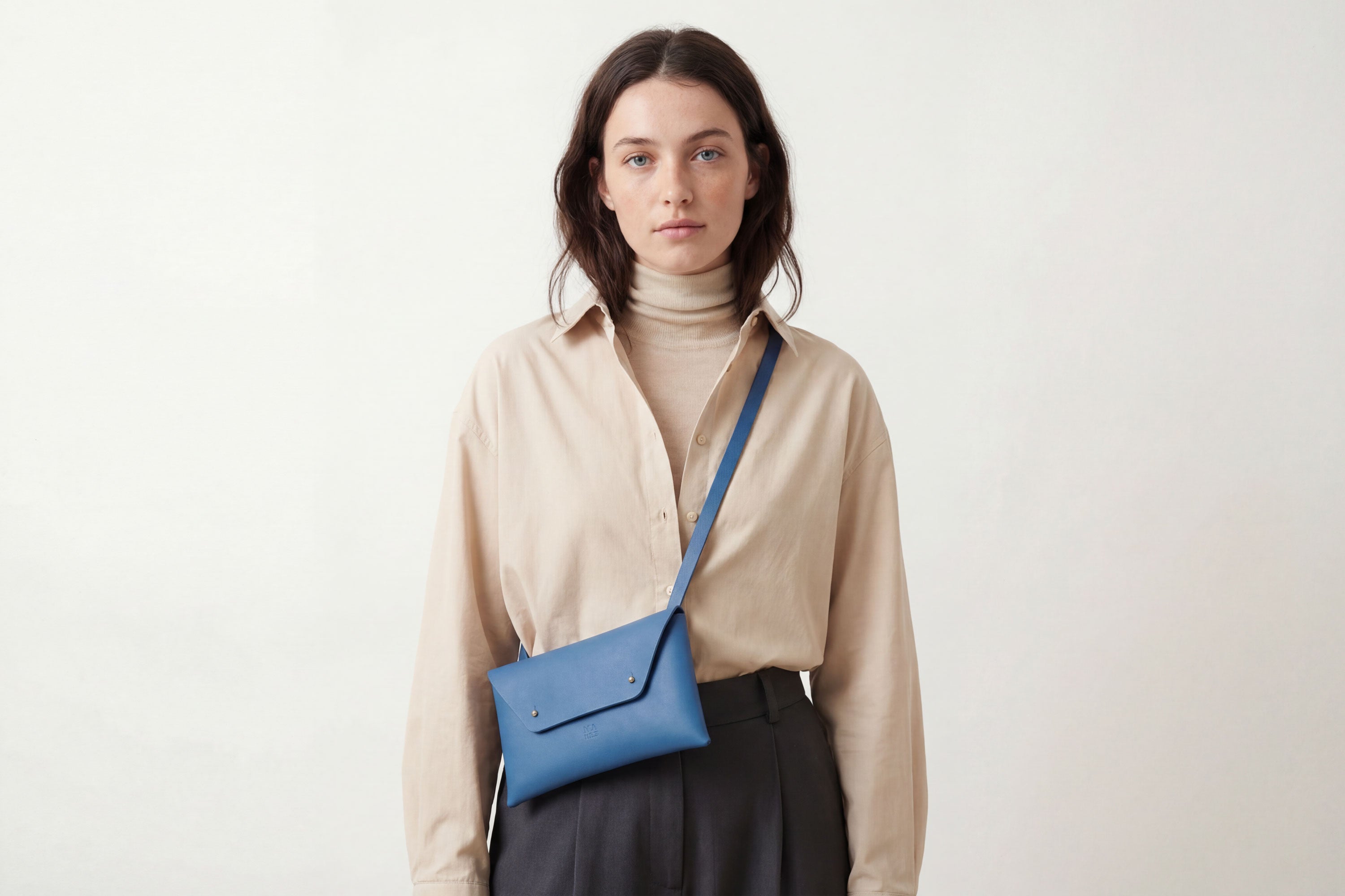 Envelope Bag With a Strap In Royal Blue Color On A Woman Model Vegetable Tanned Leather Minimalistic Design Atelier Madre Manuel Dreesmann Barcelona Spain
