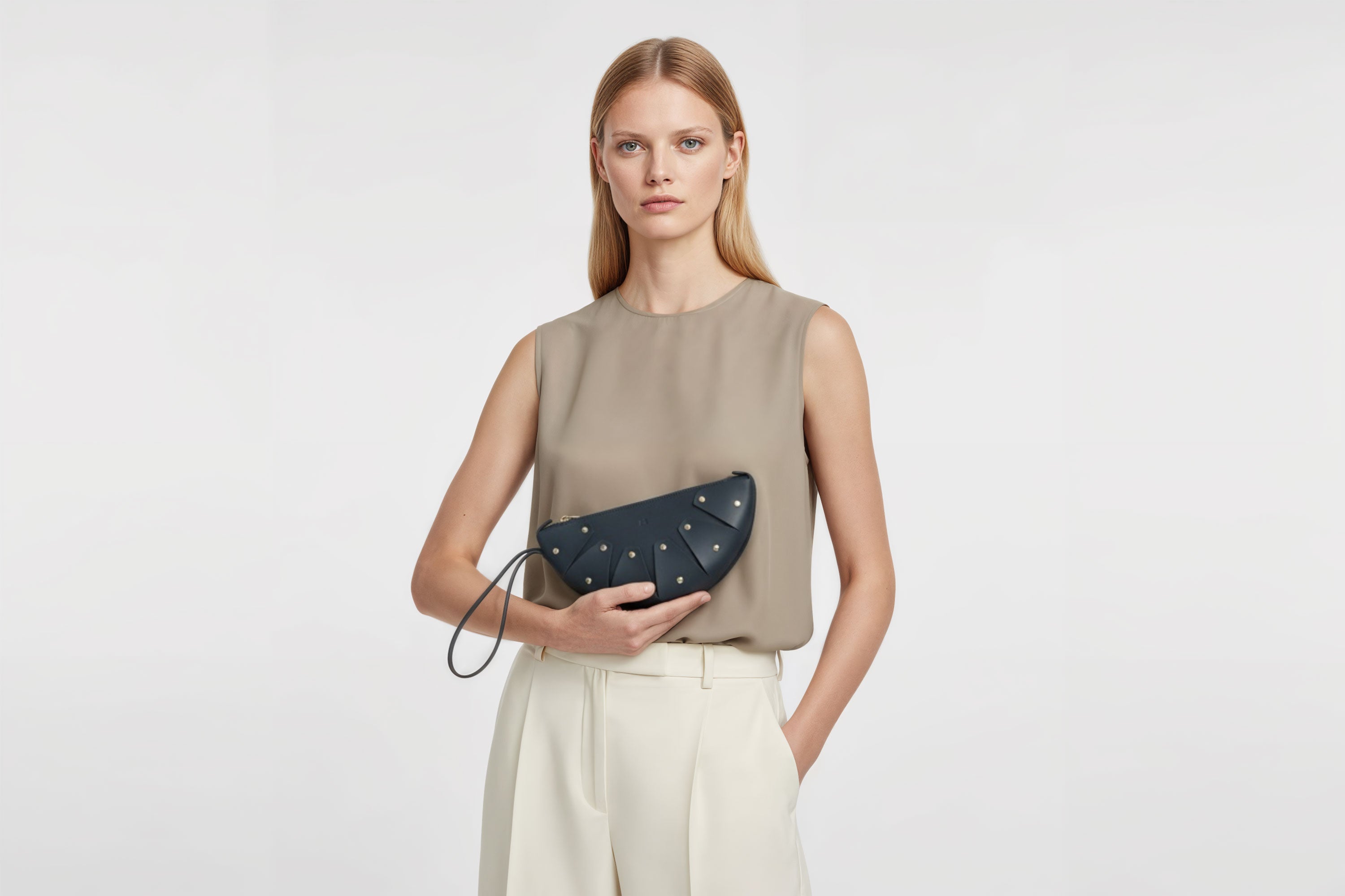 Juno Leather Bag Marine Blue Color On A Model Vegetable Tanned Full Grain Spain Brass Rivets Design Minimalist Half Moon Circle Round Zipper Pouch Handbag Clutch Bag Atelier Madre Manuel Dreesmann Barcelona