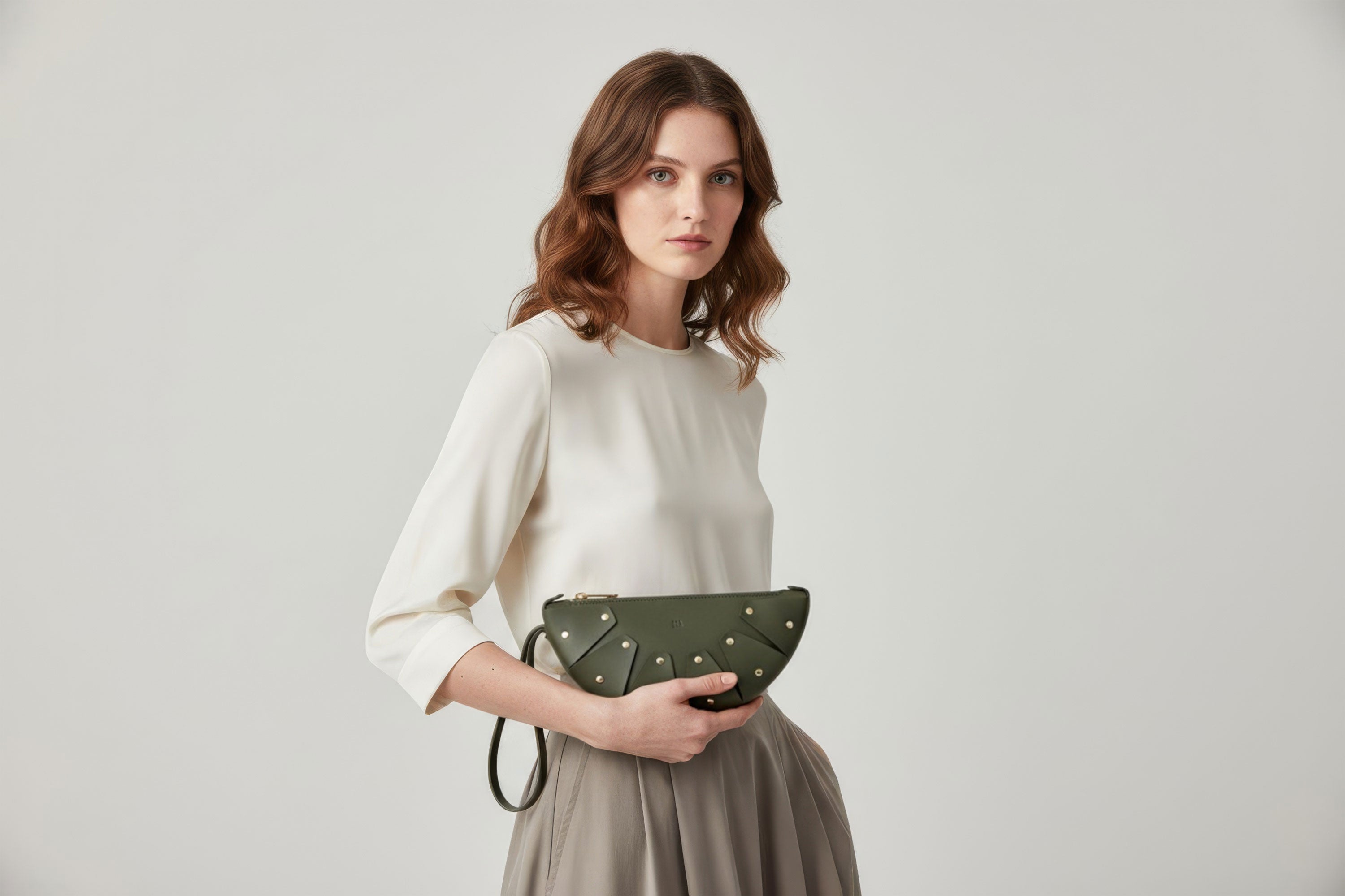 Juno Leather Bag Olive Green Color  On A Model Vegetable Tanned Full Grain Spain Brass Rivets Design Minimalist Half Moon Circle Round Zipper Pouch Handbag Clutch Bag Atelier Madre Manuel Dreesmann Barcelona