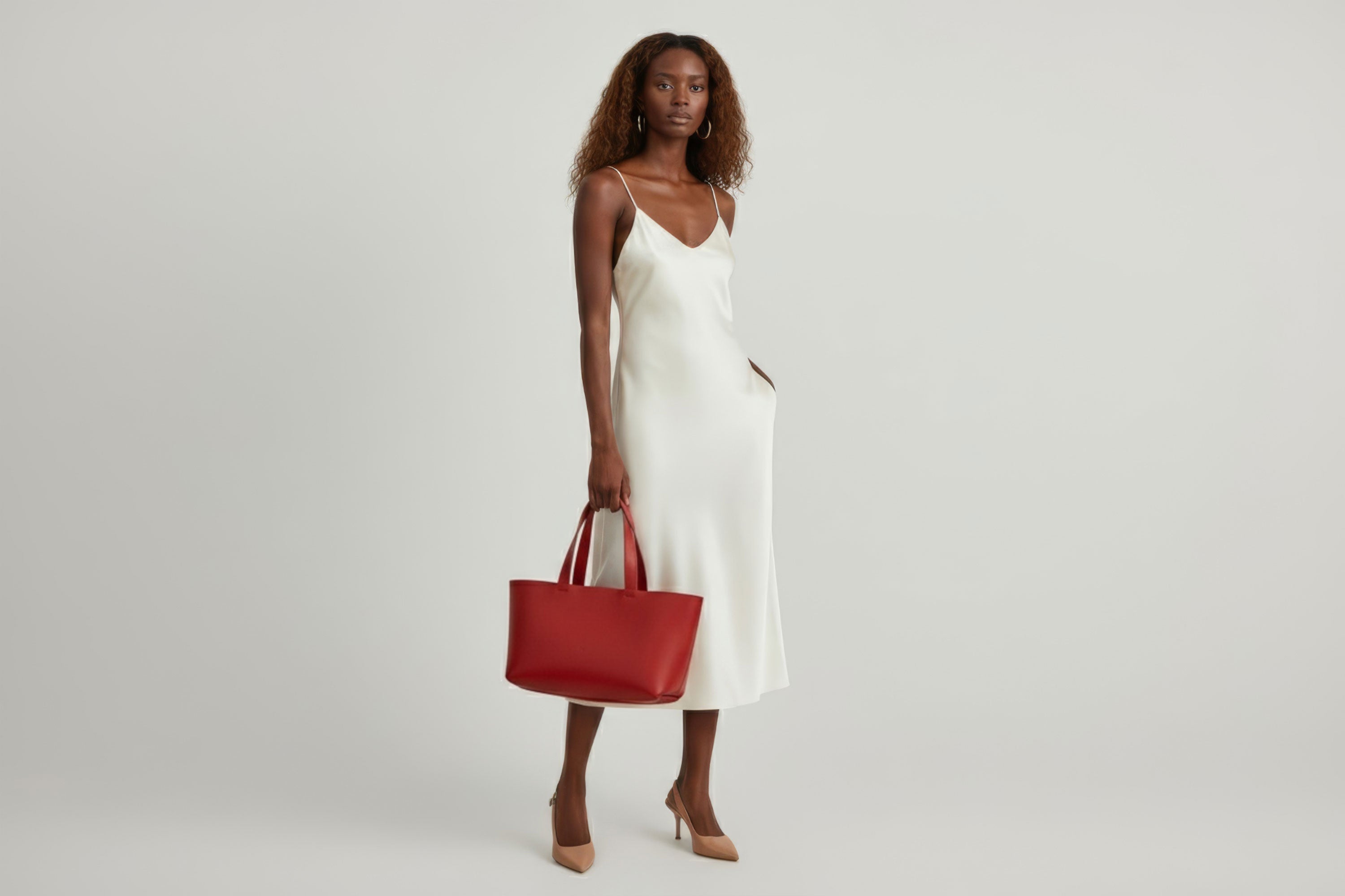 Karin Tote Bag Red Color On a Woman Model Vegetable Tanned Leather Vachetta Minimalistic Design Premium Atelier Madre Manuel Dreesmann Barcelona Spain