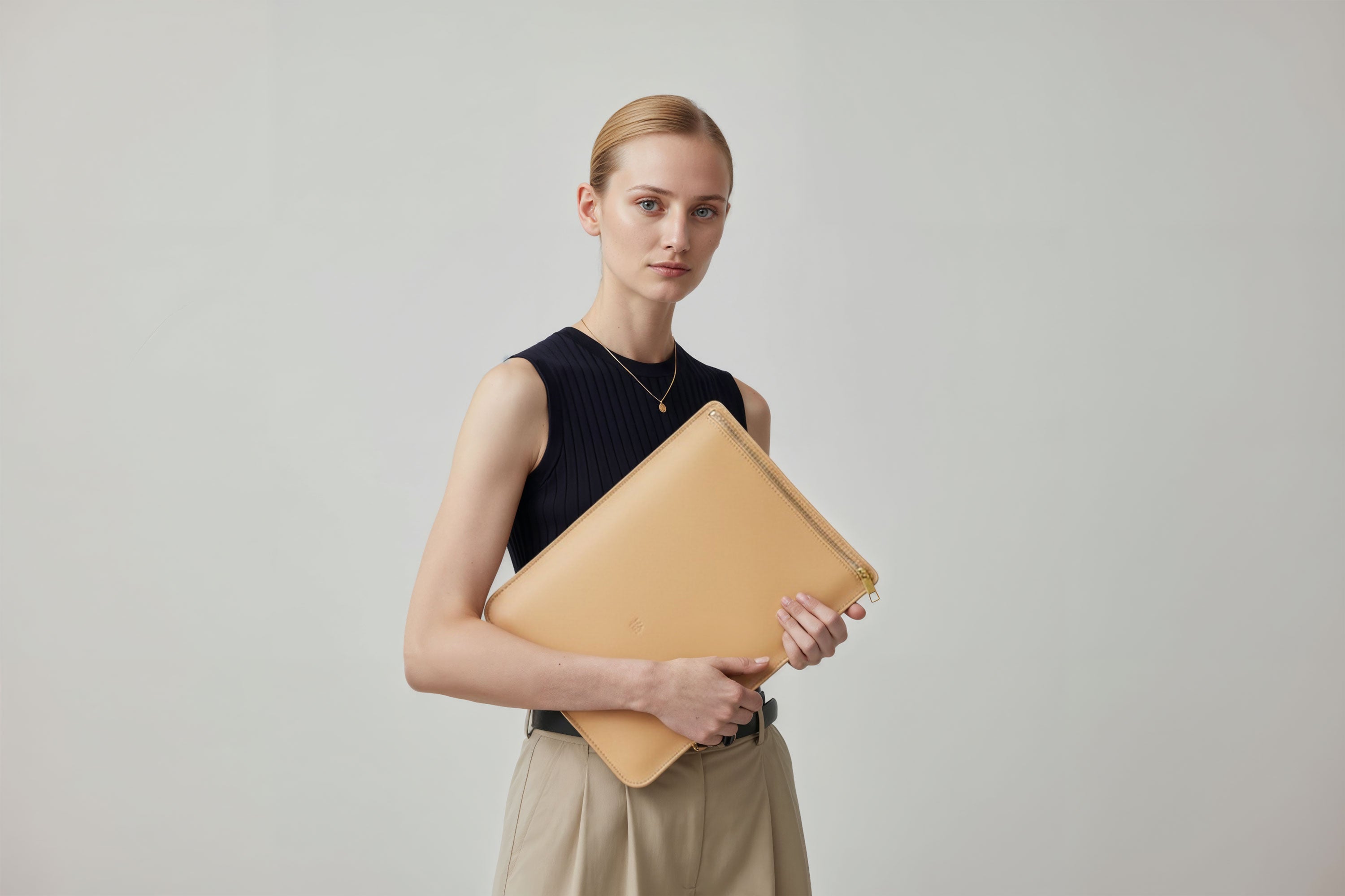 MacBook Sleeve Zipper Natural Leather Vertical On Woman Model Grey Background Minimalistic Premium Design Atelier Madre Manuel Dreesmann Barcelona