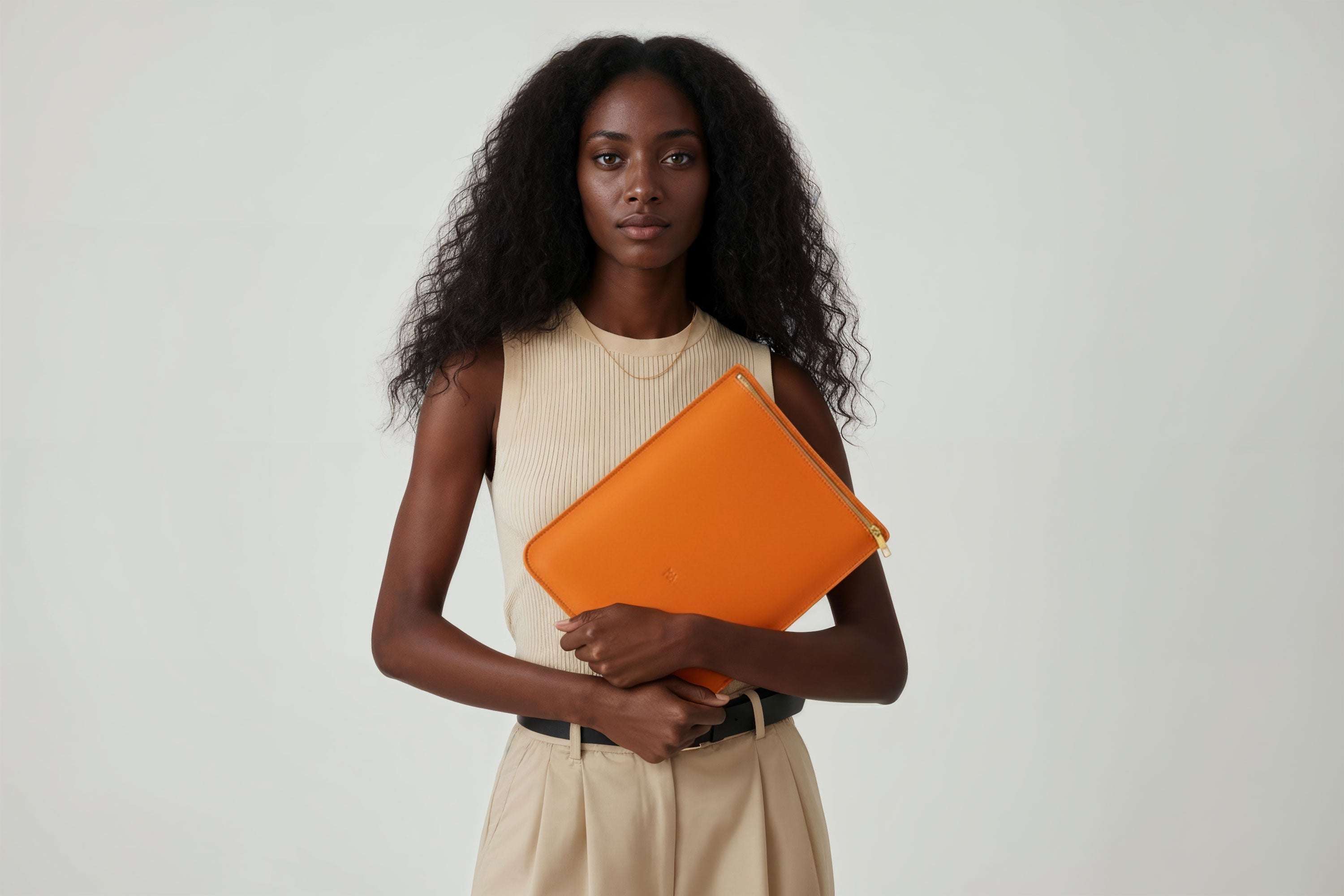 MacBook Sleeve Zipper Orange Leather Vertical On Woman Model Grey Background Minimalistic Premium Design Atelier Madre Manuel Dreesmann Barcelona