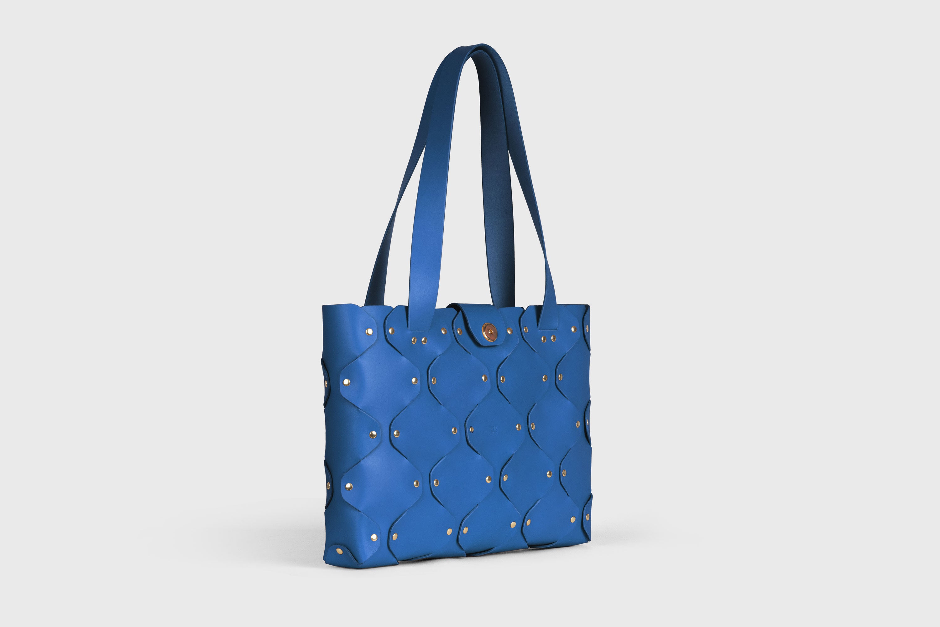 Marlin Tote Bag In Royal Blue Color On Model In Vegetable Tanned Leather With Rivets Atelier Madre Manuel Dreesmann Barcelona Spain