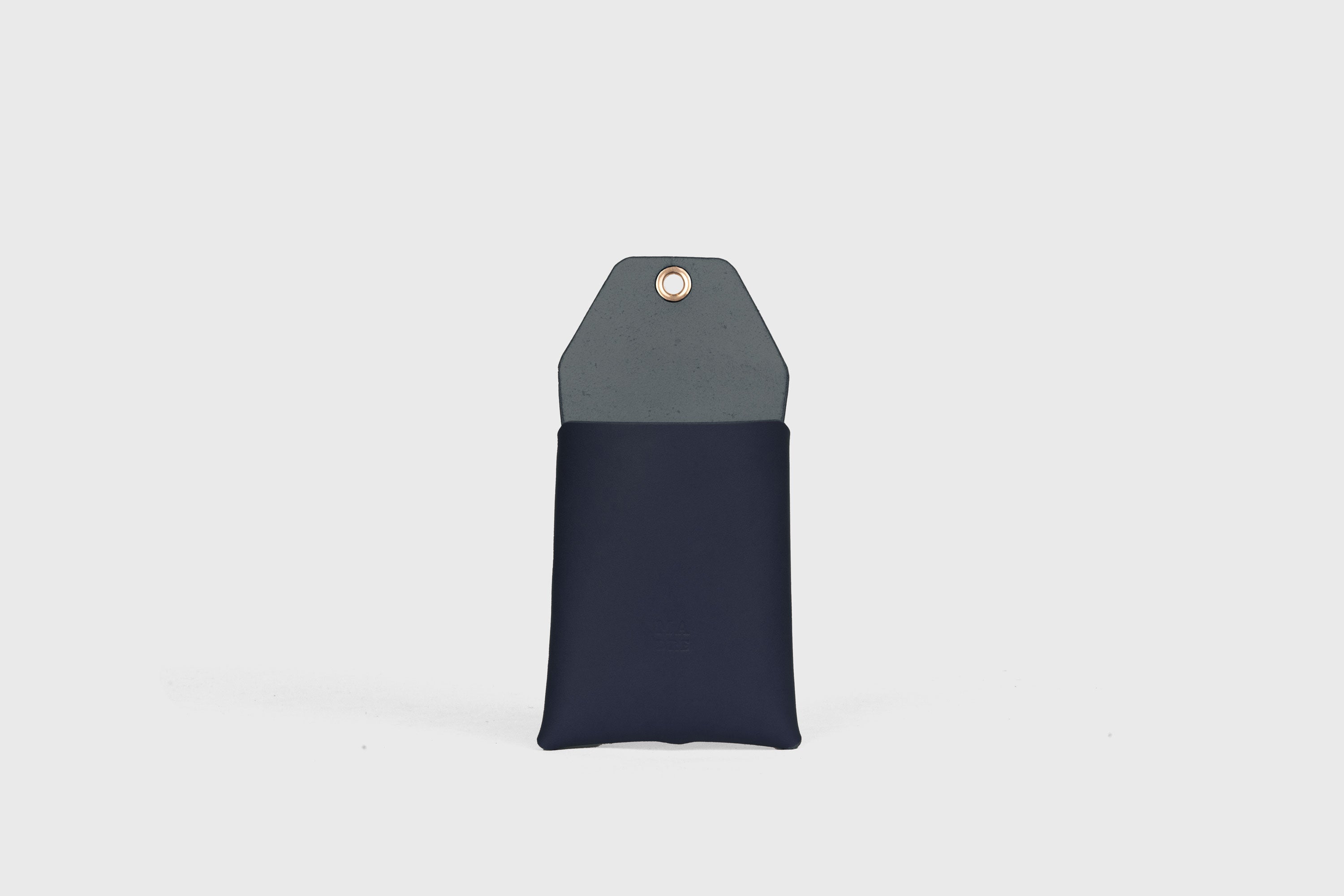 Suporte de parede para telemóvel em azul marinho em couro curtido vegetal Design minimalista com um ilhó com um orifício para o cabo de carregamento Atelier Madre Manuel Dreesmann Barcelona Espanha