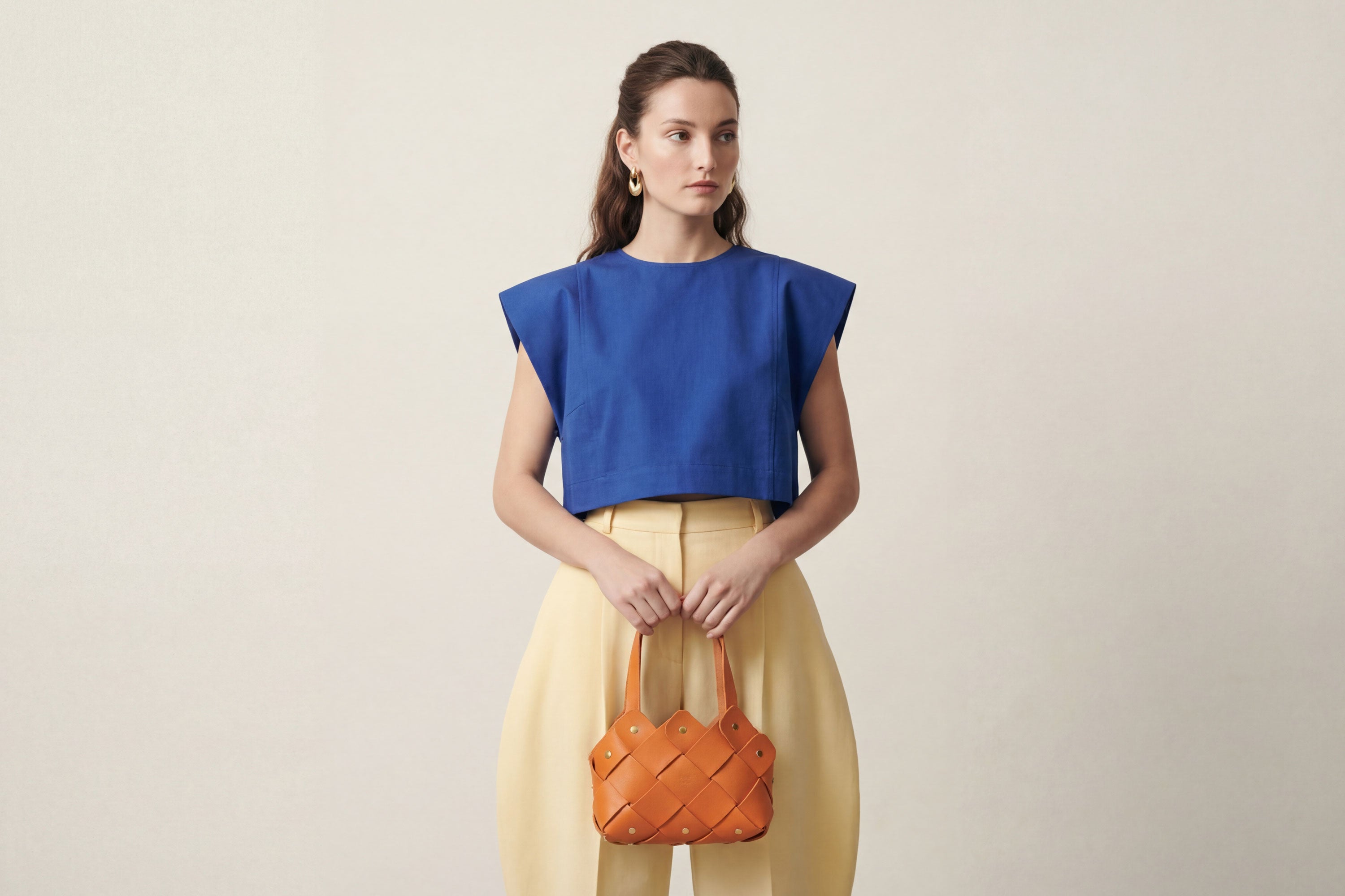 Pine Mini Tote Bag In Orange Color In Vegetable Tanned Leather On Woman Model Woven Technique and Brass Rivets Atelier Madre Manuel Dreesmann Barcelona Spain