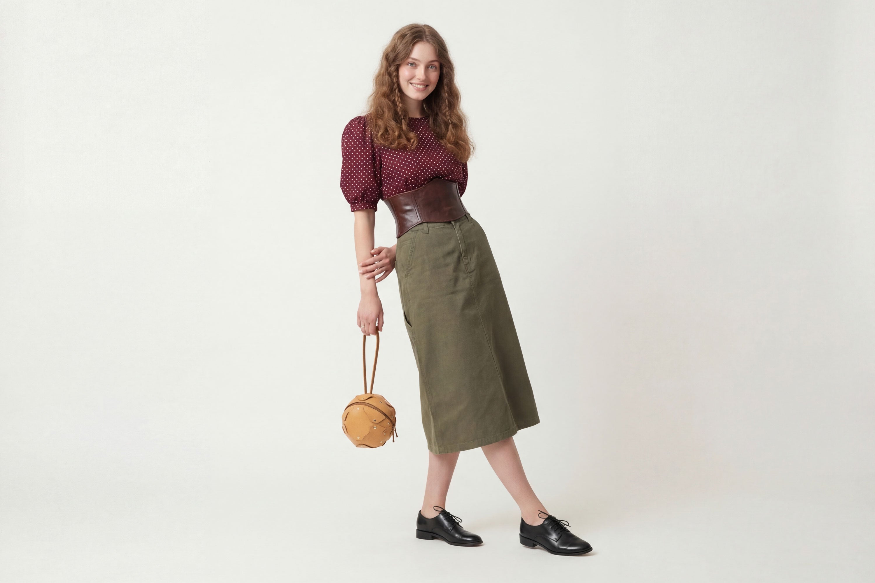 Puff Leather Ball Bag Brown Color On A Woman Model Luxury Vegetable Tanned Full Grain Spain Brass Rivets Premium Design Minimalist Modern Round Sphere Circle Round Zipper Pouch Handbag Clutch Bag Atelier Madre Manuel Dreesmann Barcelona