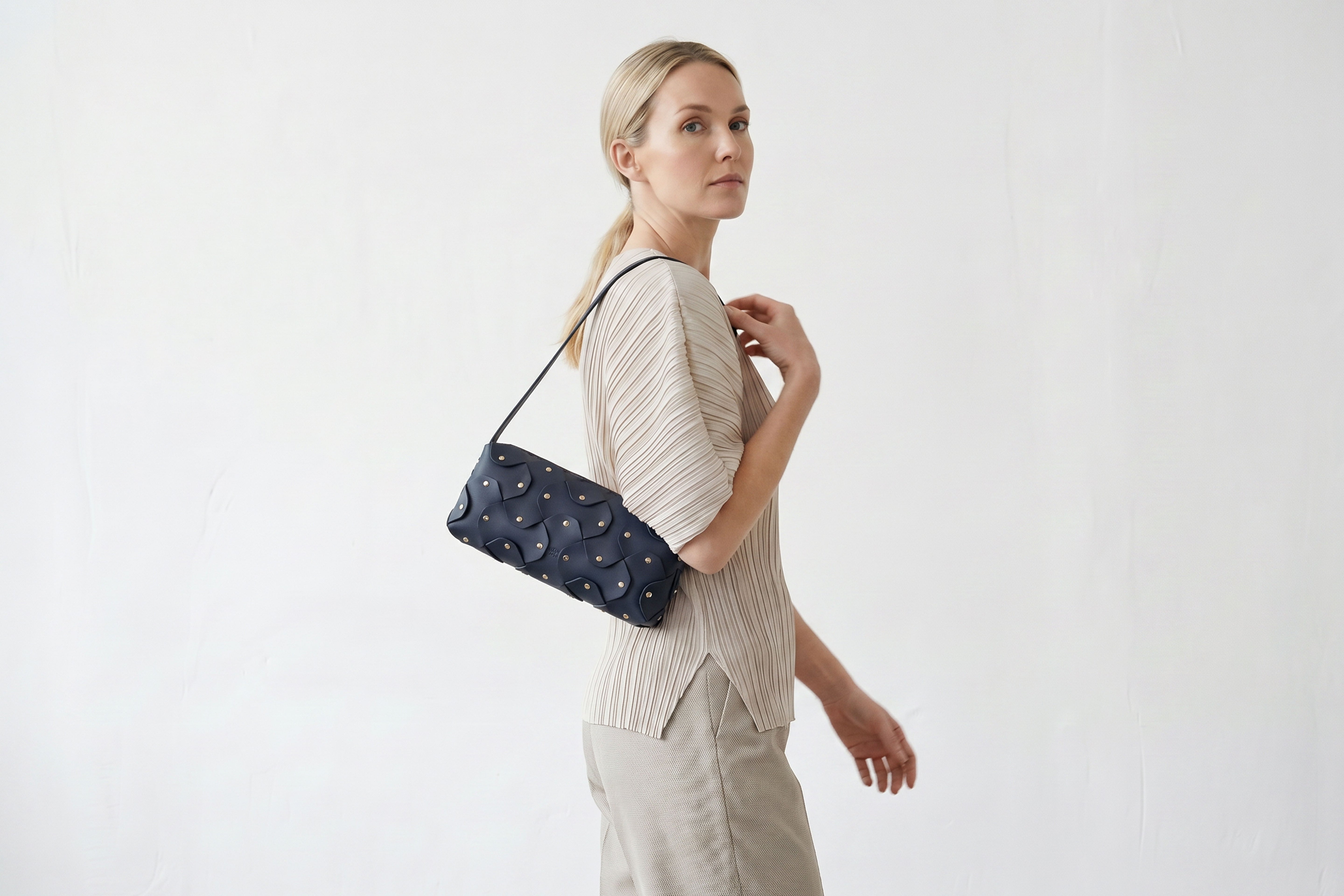 Rivet Bag 01 In Marine Blue Color On A Woman Model In Vegetable Tanned Leather With Brass Rivets Unique Design Atelier Madre Manuel Dreesmann Barcelona Spain