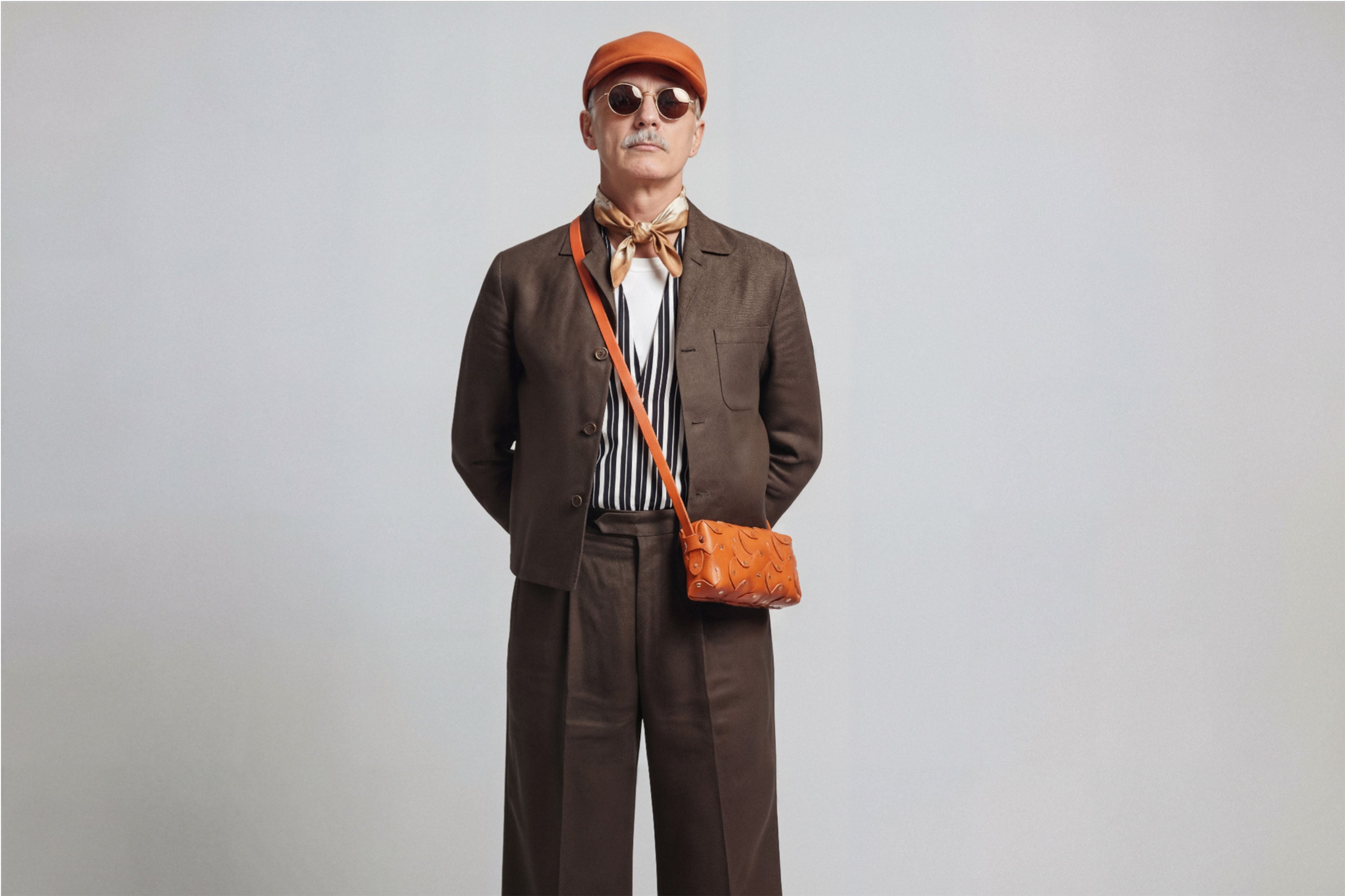 The Rivet Bag Leather Orange Color On A Man Model Vegetable Tanned Full Grain Leather Premium Quality Handbag Crossbody Shoulder Clutch Minimalistic Modern Design Atelier Madre Manuel Dreesmann Barcelona Spain