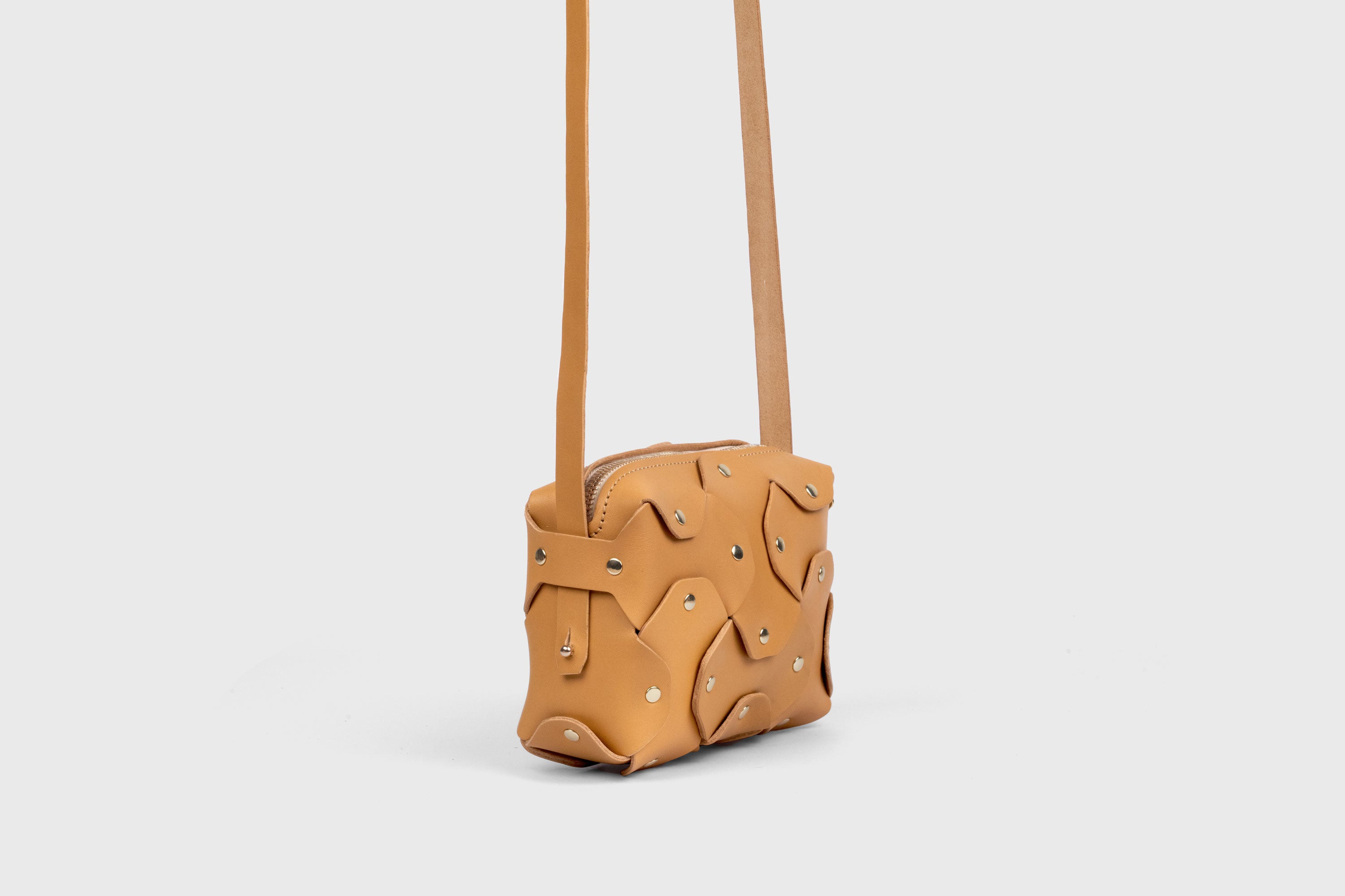 Bolso Rivet pequeño de piel marrón. Bolso de mano, bandolera y cruzado. Con tirante desmontable de latón macizo. Piel de grano completo curtida al vegetal. Alta calidad. Diseño moderno y minimalista. Atelier Madre, Manuel Dreesmann, Barcelona, España.
