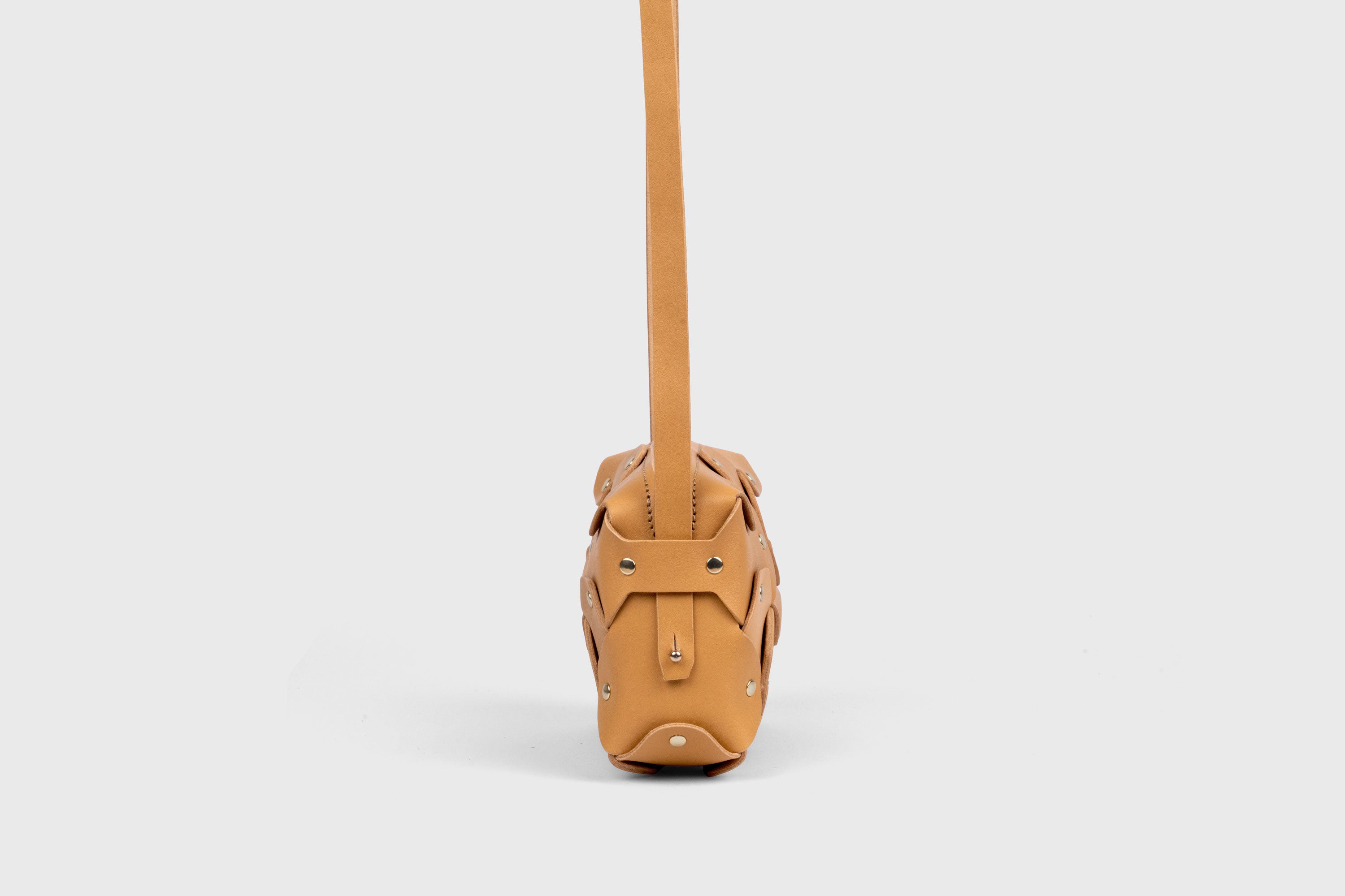 Bolso Rivet pequeño de piel marrón. Bolso de mano, bandolera y cruzado. Con tirante desmontable de latón macizo. Piel de grano completo curtida al vegetal. Alta calidad. Diseño moderno y minimalista. Atelier Madre, Manuel Dreesmann, Barcelona, España.