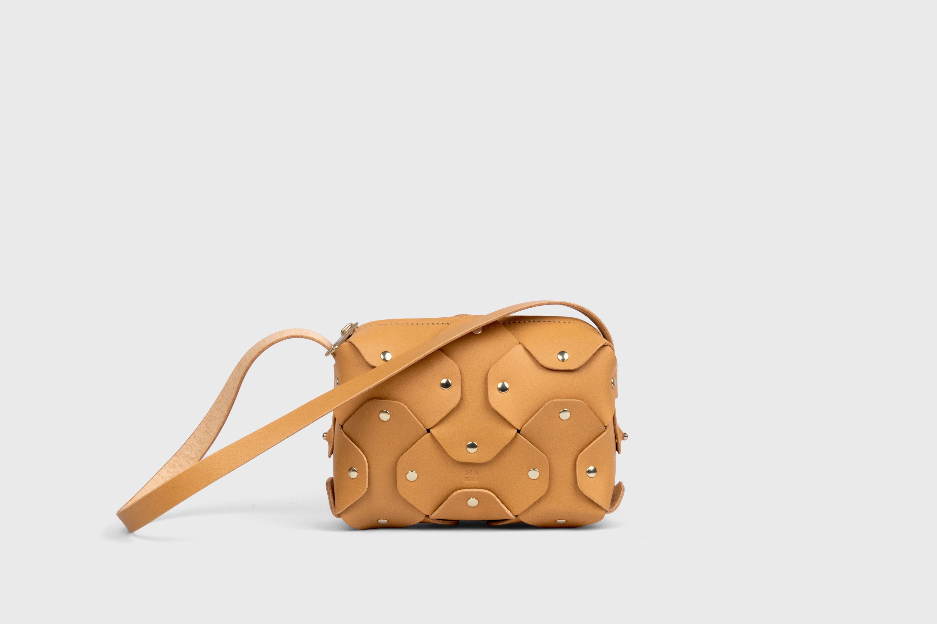 Bolso Rivet pequeño de piel marrón. Bolso de mano, bandolera y cruzado. Con tirante desmontable de latón macizo. Piel de grano completo curtida al vegetal. Alta calidad. Diseño moderno y minimalista. Atelier Madre, Manuel Dreesmann, Barcelona, España.