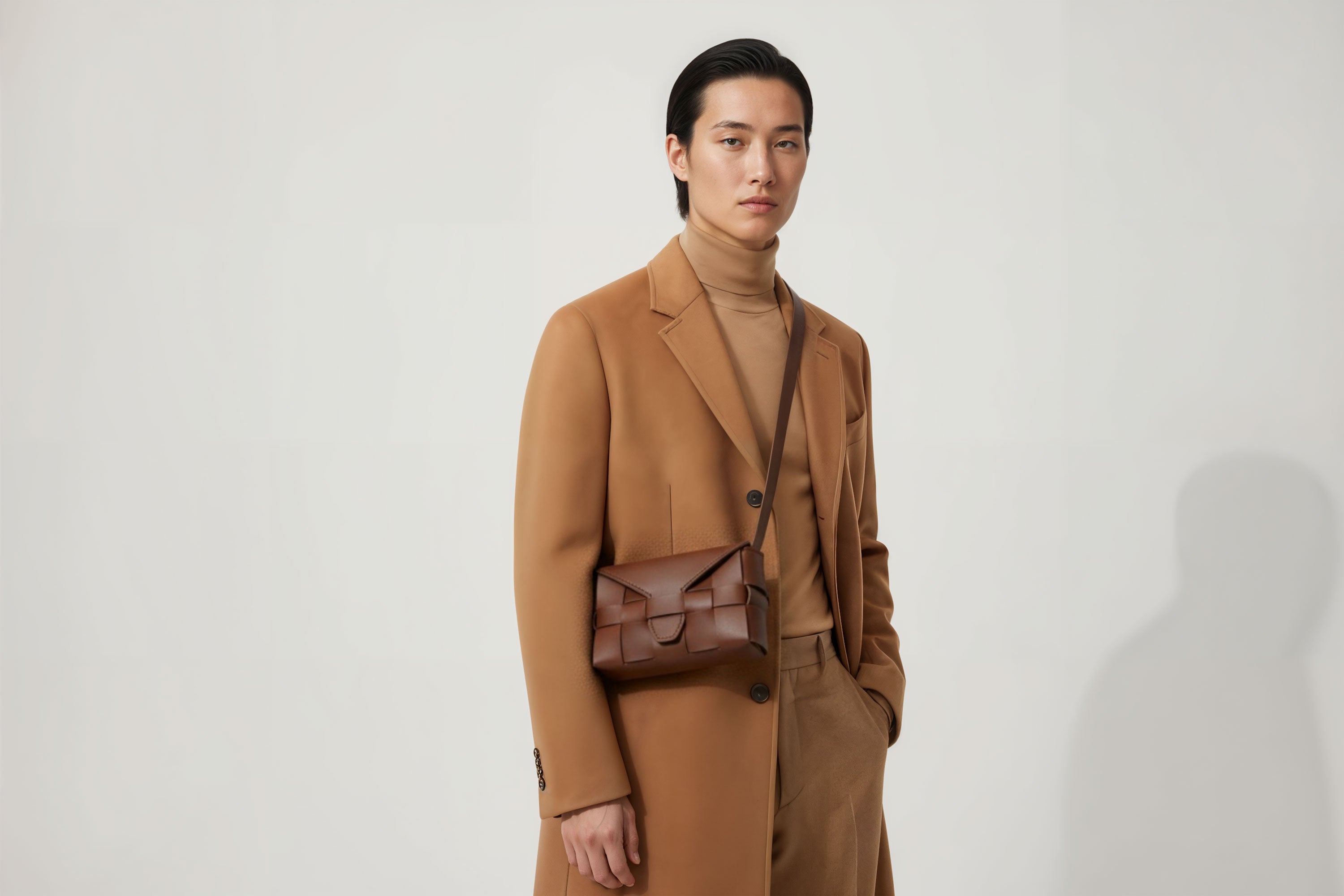 Woven Leather Bag Saka Bag Dark Brown Color Leather On Man Model Bright Background Vegetable Tanned Leather Modern Minimalist Design Premium Quality Atelier Madre Manuel Dreesmann Barcelona Spain