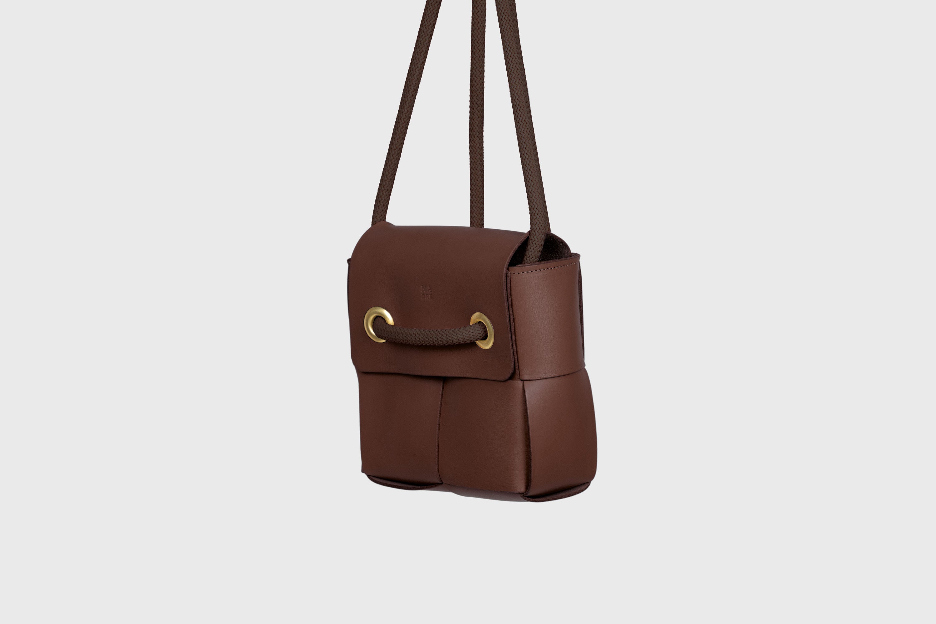 Elegant Atelier Madre Dark Brown Color woven leather backpack, designed by Manuel Dreesmann, showcasing exquisite craftsmanship and luxury style, crafted in the heart of Barcelona.
