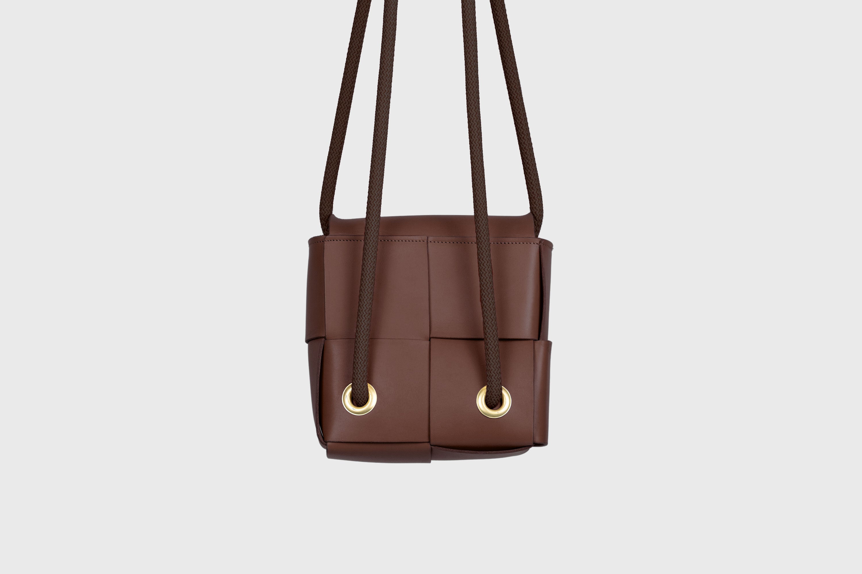 Elegant Atelier Madre Dark Brown Color woven leather backpack, designed by Manuel Dreesmann, showcasing exquisite craftsmanship and luxury style, crafted in the heart of Barcelona.