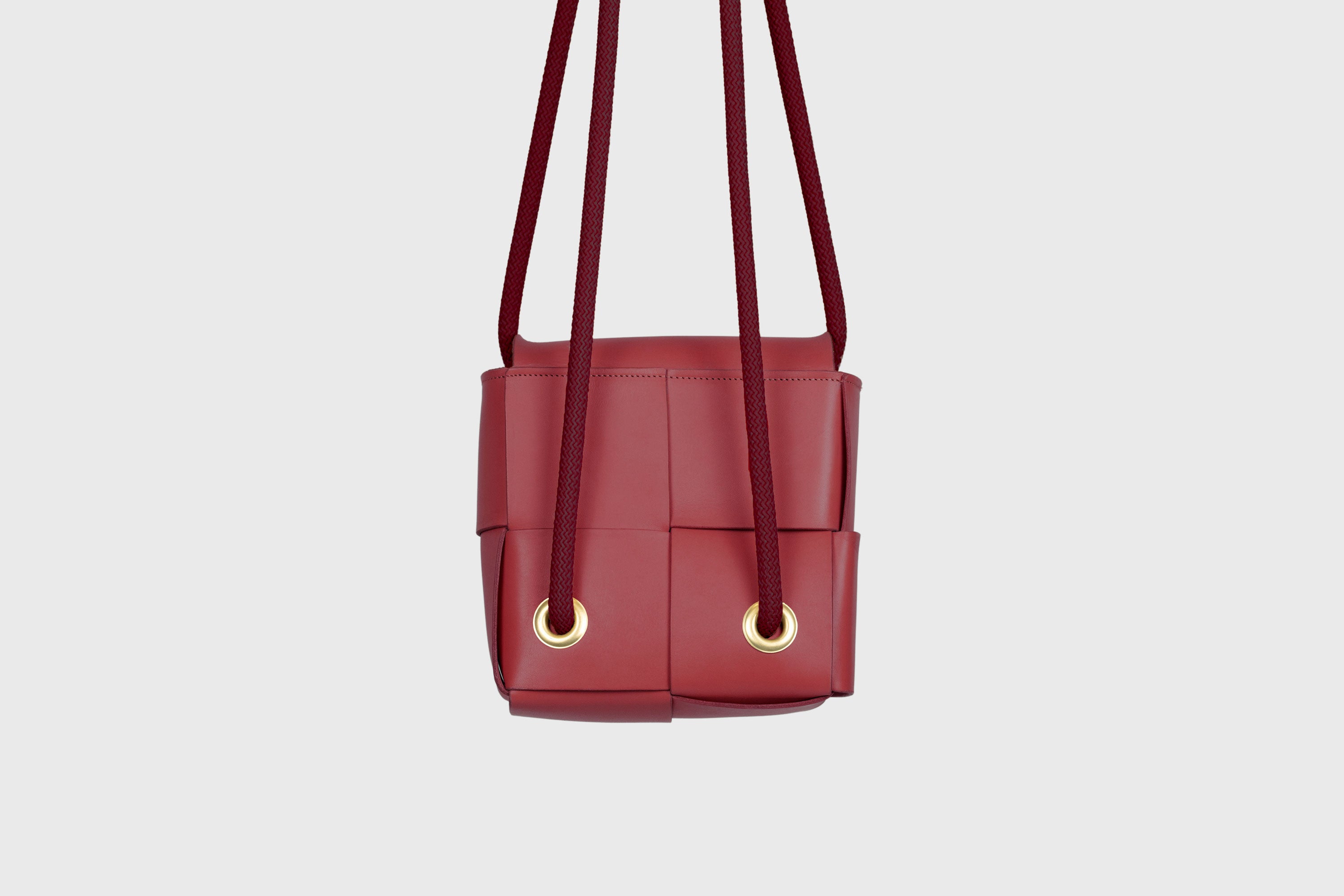 Elegant Atelier Madre Red Color woven leather backpack, designed by Manuel Dreesmann, showcasing exquisite craftsmanship and luxury style, crafted in the heart of Barcelona.