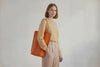 Tote Bag Long Orange Color Leather Bag On A Woman Model Vegetable Tanned Leather Exclusive Quality Craftsmanship Handmade Design By Manuel Dreesmann Atelier Madre Barcelona Spain