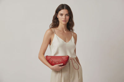 Juno Leather Bag Red Color On A Model Vegetable Tanned Full Grain Spain Brass Rivets Design Minimalist Half Moon Circle Round Zipper Pouch Handbag Clutch Bag Atelier Madre Manuel Dreesmann Barcelona