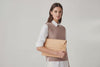 Model is holding a leather sleeve for a MacBook in natural color in front of bright background Video Loop minimalistic design atelier Madre Manuel Dreesmann Barcelona Spain