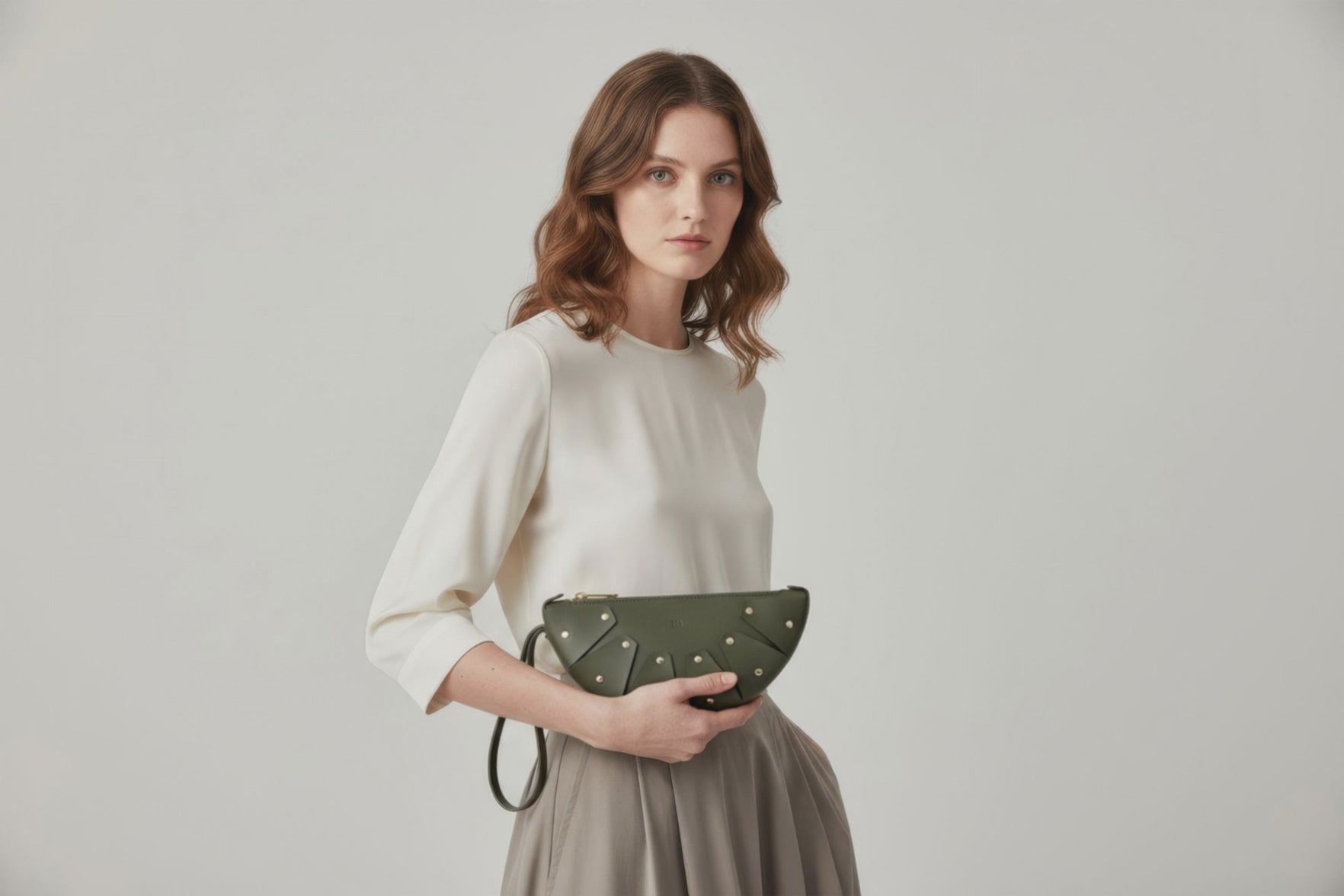 Juno Leather Bag Olive Green Color  On A Model Vegetable Tanned Full Grain Spain Brass Rivets Design Minimalist Half Moon Circle Round Zipper Pouch Handbag Clutch Bag Atelier Madre Manuel Dreesmann Barcelona