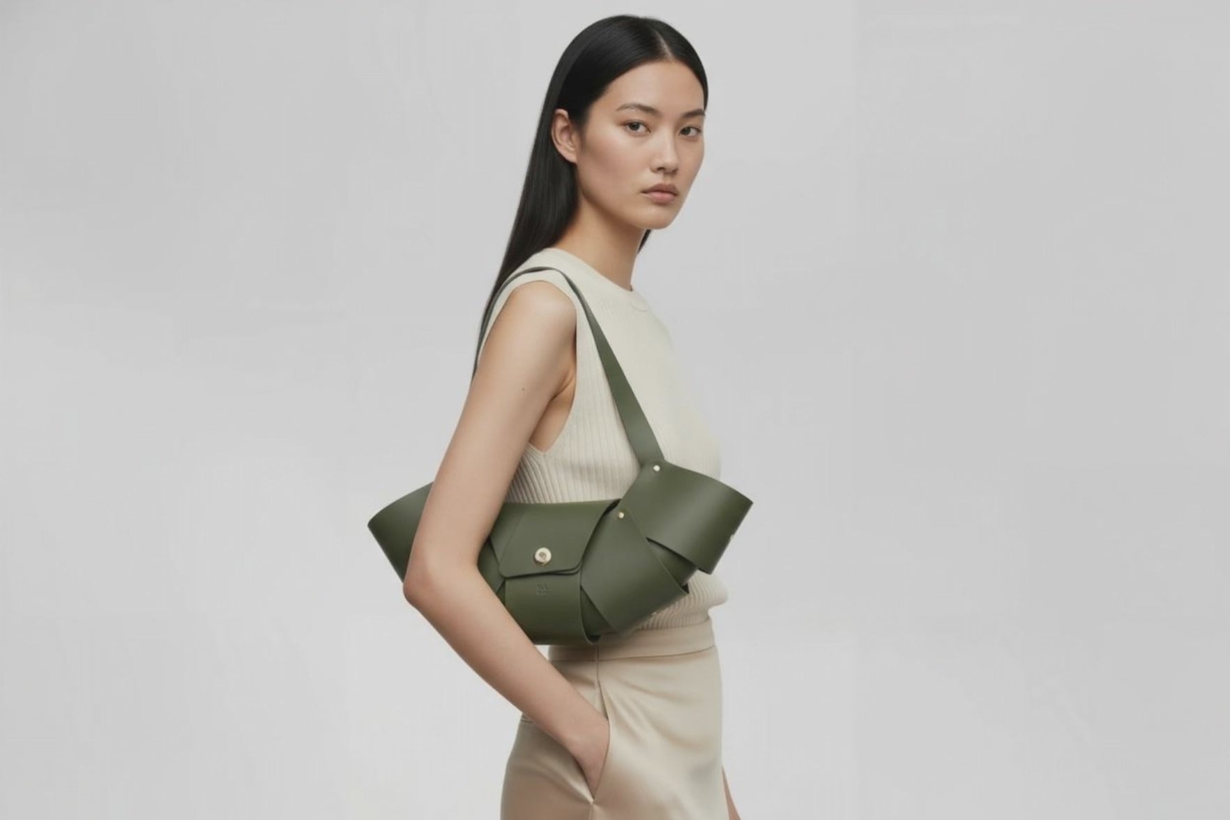 Croissant Bag Big Olive Green Color Leather Magnetic Closure On A Woman Model Full Grain Vegetable Tanned Leather High Quality Modern Minimalistic Organic Design Full Brass Rivets Atelier Madre Manuel Dreesmann Barcelona Spain
