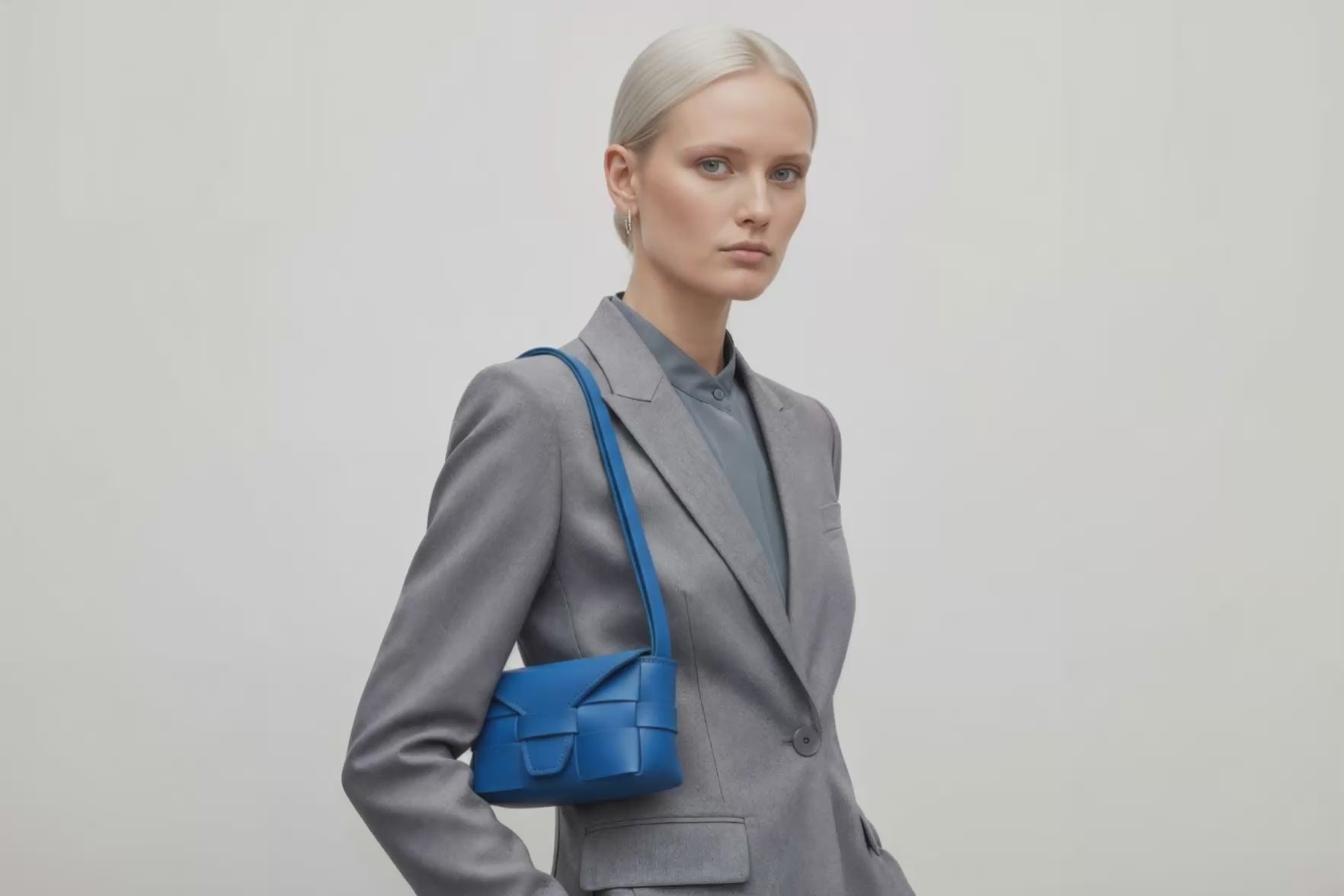 Woman wearing the royal blue small saka leather bag against a plain background. Video Loop Minimalist design from Atelier Madre - Manuel Dreesmann in Barcelona