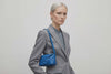 Woman wearing the royal blue small saka leather bag against a plain background. Video Loop Minimalist design from Atelier Madre - Manuel Dreesmann in Barcelona