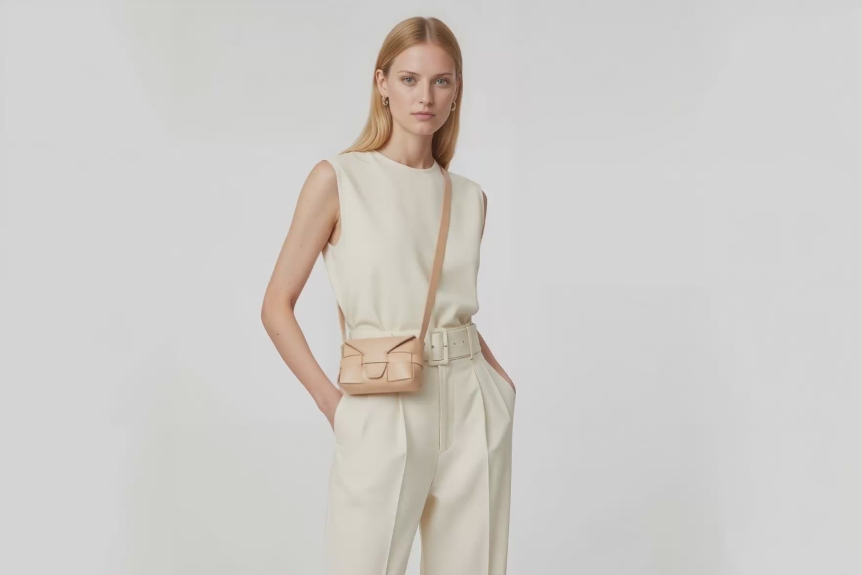 Woman wearing the natural color small saka leather bag against a plain background. Video Loop Minimalist design from Atelier Madre - Manuel Dreesmann in Barcelona