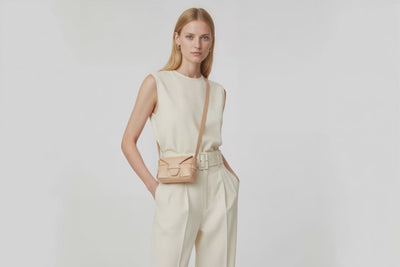 Woman wearing the natural color small saka leather bag against a plain background. Video Loop Minimalist design from Atelier Madre - Manuel Dreesmann in Barcelona