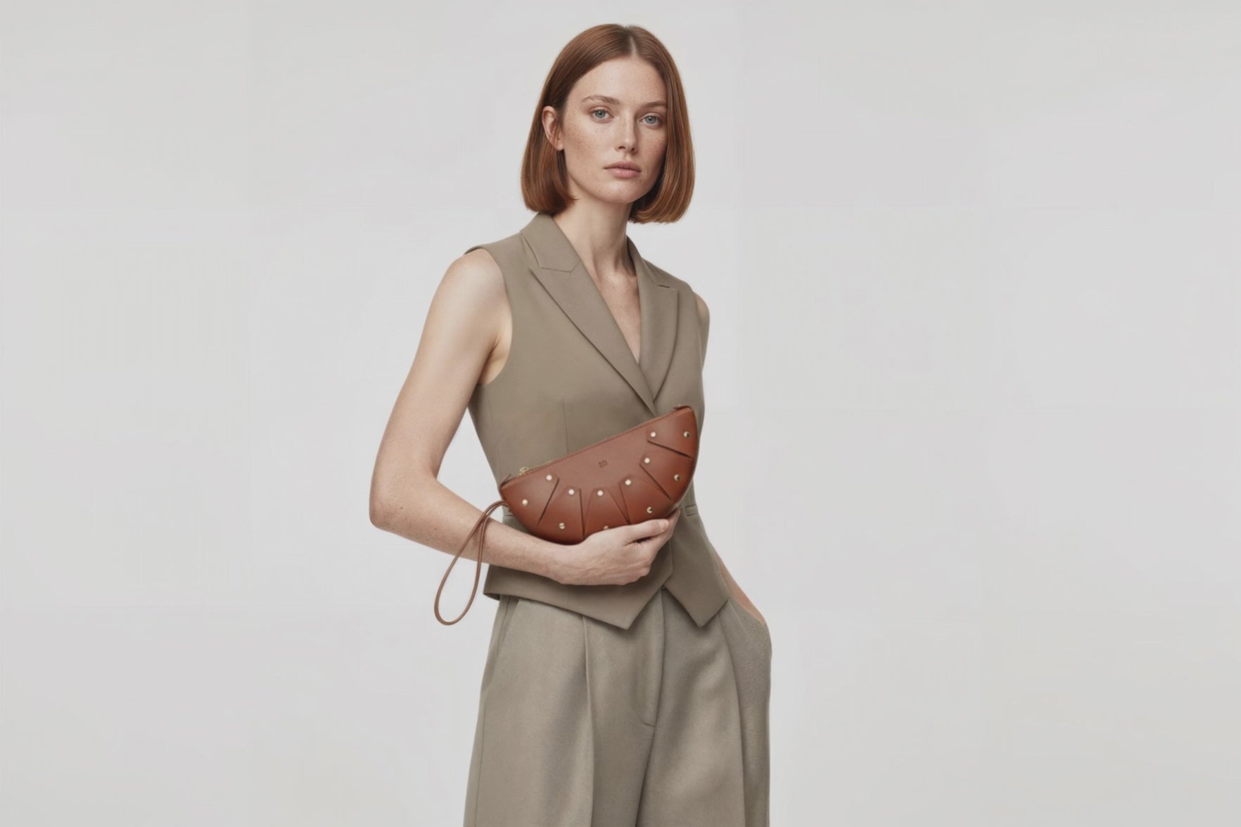 Juno Leather Bag Dark Brown On A Model Vegetable Tanned Full Grain Spain Brass Rivets Design Minimalist Half Moon Circle Round Zipper Pouch Handbag Clutch Bag Atelier Madre Manuel Dreesmann Barcelona