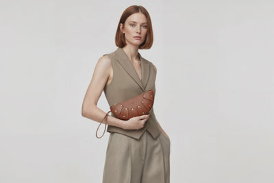 Juno Leather Bag Dark Brown On A Model Vegetable Tanned Full Grain Spain Brass Rivets Design Minimalist Half Moon Circle Round Zipper Pouch Handbag Clutch Bag Atelier Madre Manuel Dreesmann Barcelona