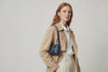 Woman wearing the marine blue small saka leather bag against a plain background. Video Loop Minimalist design from Atelier Madre - Manuel Dreesmann in Barcelona