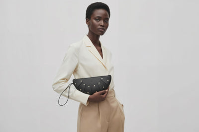 Juno Leather Bag Black Color On A Model Vegetable Tanned Full Grain Spain Brass Rivets Design Minimalist Half Moon Circle Round Zipper Pouch Handbag Clutch Bag Atelier Madre Manuel Dreesmann Barcelona