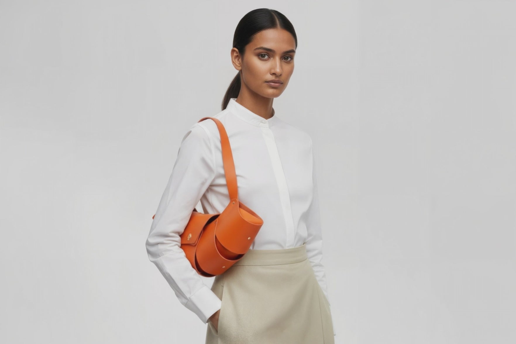 Croissant Bag Big Orange Leather Magnetic Closure On A Woman Model Full Grain Vegetable Tanned Leather High Quality Modern Minimalistic Organic Design Full Brass Rivets Atelier Madre Manuel Dreesmann Barcelona Spain