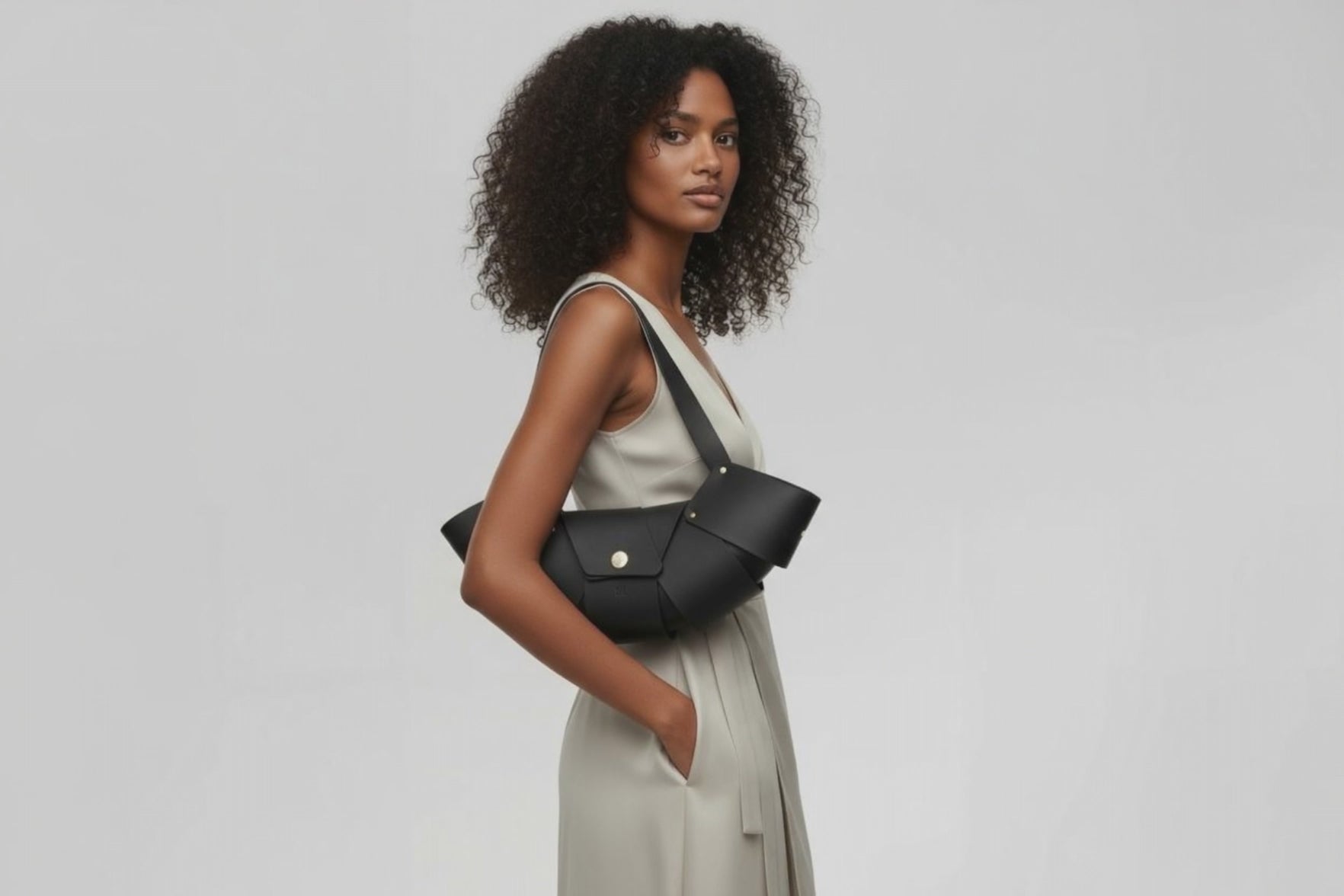 Croissant Bag Big Black Leather Magnetic Closure On A Woman Model Full Grain Vegetable Tanned Leather High Quality Modern Minimalistic Organic Design Full Brass Rivets Atelier Madre Manuel Dreesmann Barcelona Spain