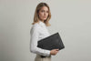 Model is holding a leather sleeve for a MacBook in black color in front of bright background Video Loop minimalistic design atelier Madre Manuel Dreesmann Barcelona Spain