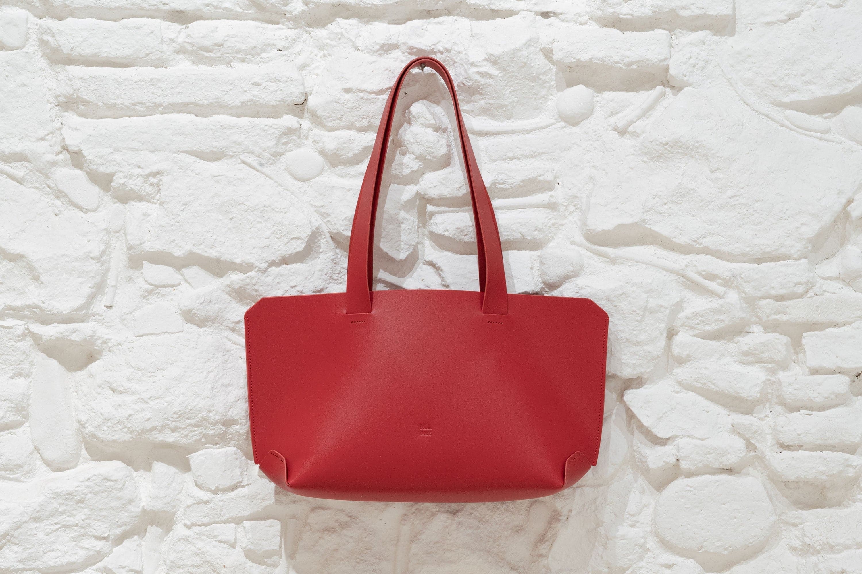 Tote Bag Red Color Vegetable Tanned Leather Hanging on Wall German Design By Manuel Dreesmann Atelier Madre Barcelona Spain