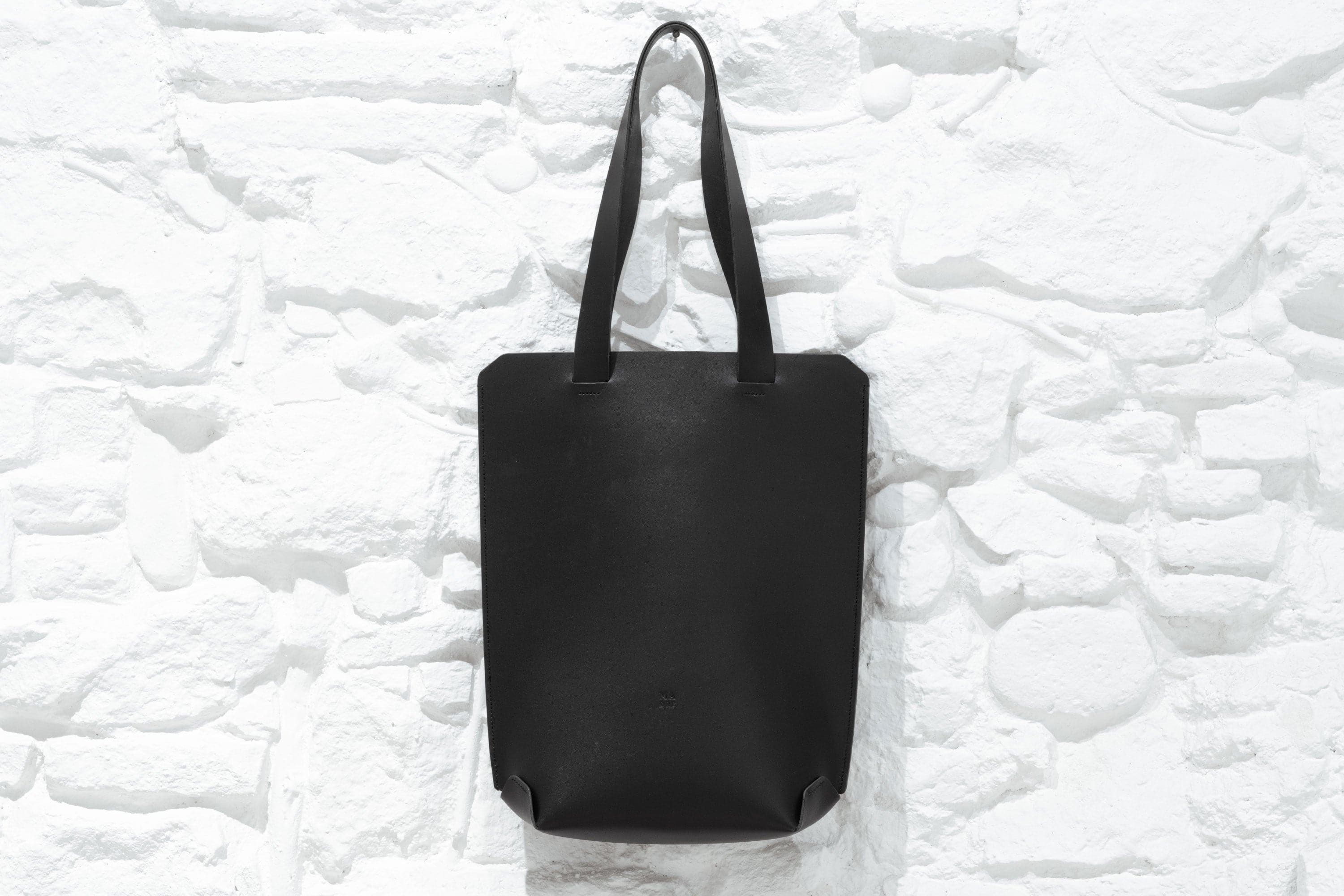 Tote Bag Long Version Black Leather Vachetta Modern Premium Hanging on Wall Design By Manuel Dreesmann Atelier Madre Barcelona Spain